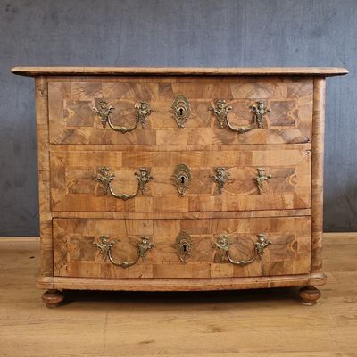 an old wooden chest of drawers with brass handles on a wooden floor