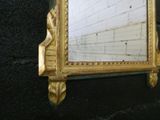 a mirror hanging on a wall with a brick wall in the background