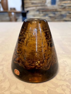 a brown vase sitting on a table with a white table cloth
