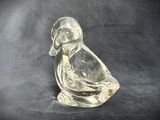 clear glass duck figurine sitting on a black surface