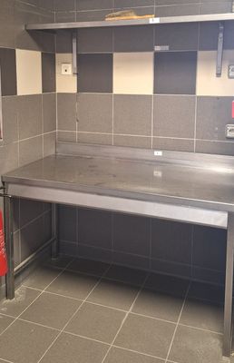 une cuisine avec un plan de travail en inox et un extincteur rouge