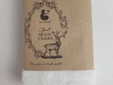a close up of a white towel with a deer on it