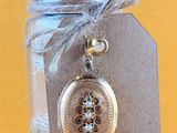 a small glass jar with a silver locke on it