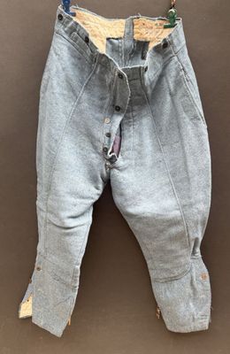 an old pair of jeans hanging on a hanger on a wall