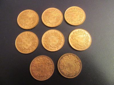 six types différents de pièces d'or sur une surface noire