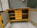a yellow workbench in a room with a lot of drawers