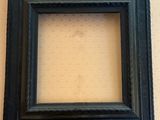 a black picture frame on a wall with a white wall behind it