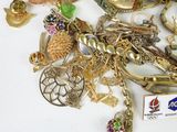 a pile of gold and silver jewelry on a white surface