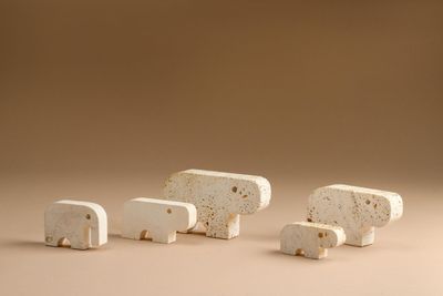 trois petites figurines d'éléphants blanches posées sur une table