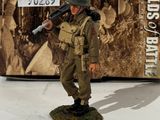 toy figurine of a soldier with a machine gun in front of a box