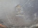 a silver plate with a metal handle on a table