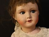 a doll that is sitting on a black surface