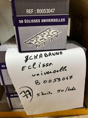 une pile de cartons sur laquelle est accrochée une pancarte