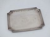 an antique silver tray with a flower design on it