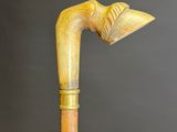 a close up of a wooden walking stick with a bird head on it