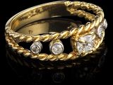 gros plan d'une bague en or avec des diamants sur une surface noire