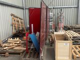 several pallets of wood are stacked in a warehouse with a red door