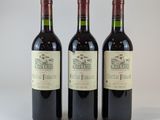 trois bouteilles de vin rouge posées côte à côte sur une table