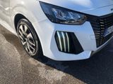 the front end of a white car parked in a parking lot