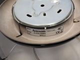 a white stove top with a metal burner on it