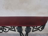 a table with a red top sitting on a sidewalk