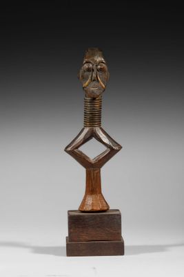 une photo d'une sculpture en bois représentant une tête posée sur un socle