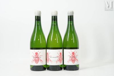 trois bouteilles de vin posées les unes à côté des autres sur une surface blanche