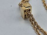 a close up of a gold necklace with a chain attached to it