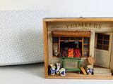a small wooden box with a doll house inside of it