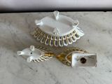 a white plate with a bird on it next to two other dishes