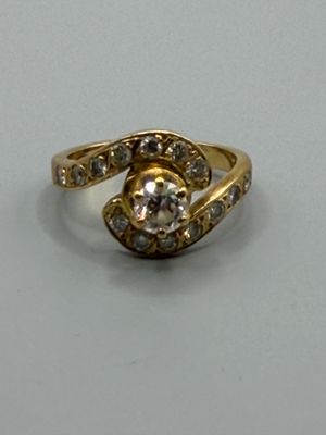une image d'une bague en or avec des diamants sur une surface blanche