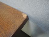 a close up of a wooden table with a white wall