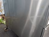 a stainless steel refrigerator that is outside on the street