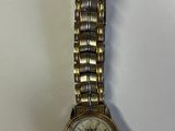 une image d'une montre-bracelet de femme sur une surface blanche