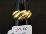 une bague en or posée sur une bouteille de vin