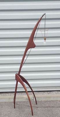 une sculpture en bois et en métal posée sur le trottoir