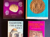 trois livres posés sur une table, avec une pièce de monnaie dessus