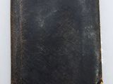 an old black book with a gold anchor on it