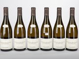 six bouteilles de vin sont alignées sur une table