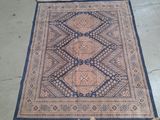 Le tapis au sol est bleu et beige, avec un motif en losanges