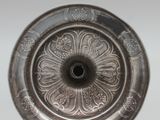 an image of a silver plate with a flower design on it