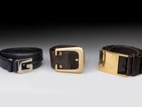 three leather belts with gold buckles on a white background