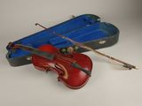 un violon rouge et un étui à violon bleu posés sur une surface blanche