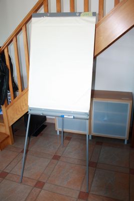 a white board on a stand in the corner of a room