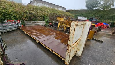 a large metal container sitting in the middle of a parking lot