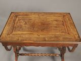 an old wooden table with a square top on a gray background