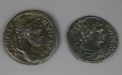 two roman coins, one of which has a head of a man and the other of which is a woman