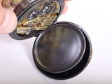 a person that is holding a pocket watch in their hand