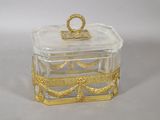 a small glass box with a gold decoration on it