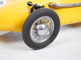 a yellow race car with a number on the front wheel